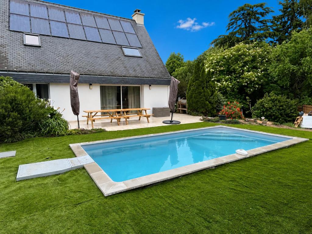a swimming pool in the yard of a house at La Parenthèse -piscine in Ploemeur