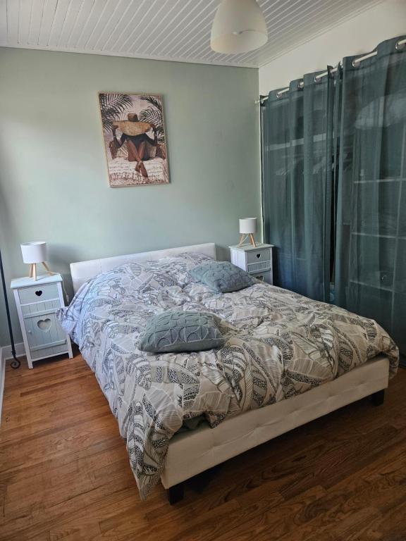a bedroom with a bed and two night stands at Ici et nulle part ailleurs in Saint-Vivien-de-Médoc