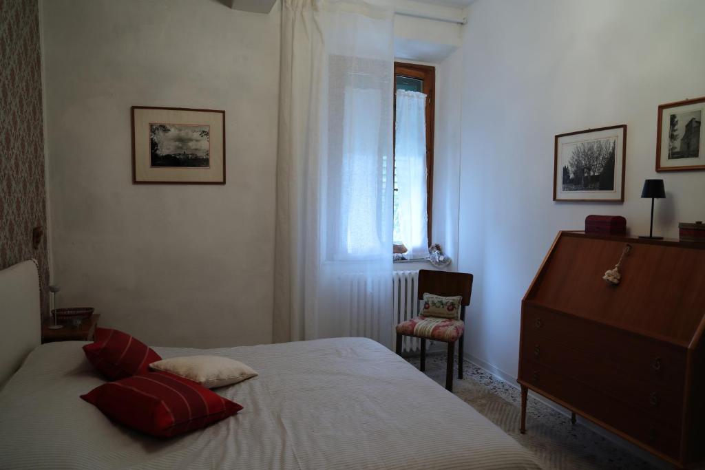 a bedroom with a bed with red pillows and a window at Casa di Sergio in Gambassi Terme