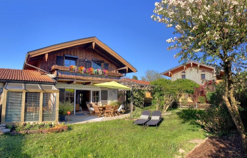 a house with a table and chairs in a yard at AlpenLodge Chiemsee in Nußdorf
