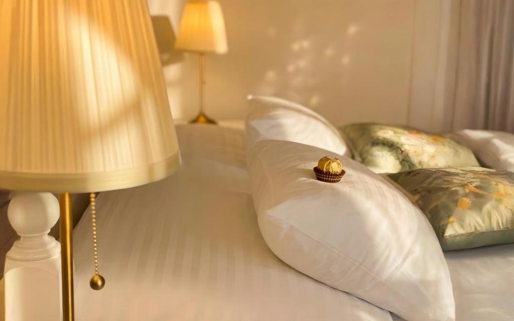 a white bed with a pillow with a crown on it at Mekcsey Udvar in Eger