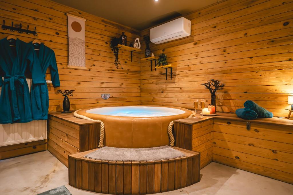 a bathroom with a tub in a wooden room at Private spa - La Sparenthèse in Ciney