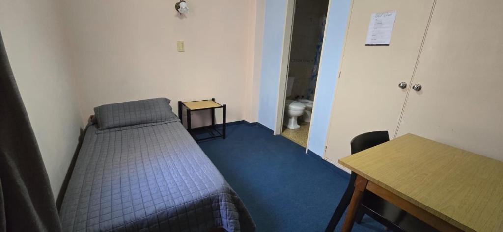 a small room with a bed and a table at Hotel Oviedo in Río Gallegos