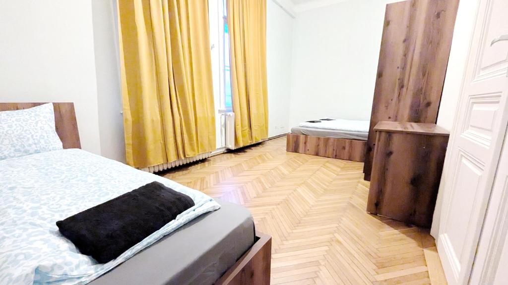 ein Schlafzimmer mit zwei Betten und Holzboden in der Unterkunft Lovely Apartment - 15 Min from Airport & City Center EZ 9 6 in Wien