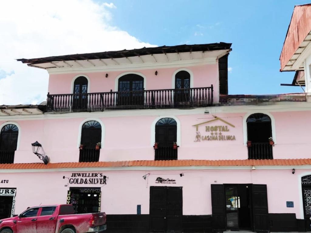 a building with a red truck parked in front of it at Casona del Inca Cajamarca in Cajamarca