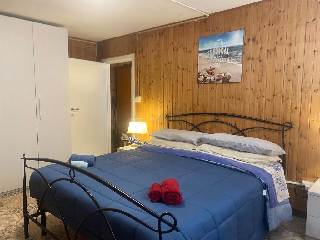 a bedroom with a blue bed with two red pillows at Logudoro Cabin by Holiday World in Alghero