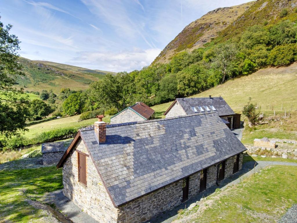 an aerial view of a stone house in the hills at Cwm Clyd Longhouse in Llanwrthwl