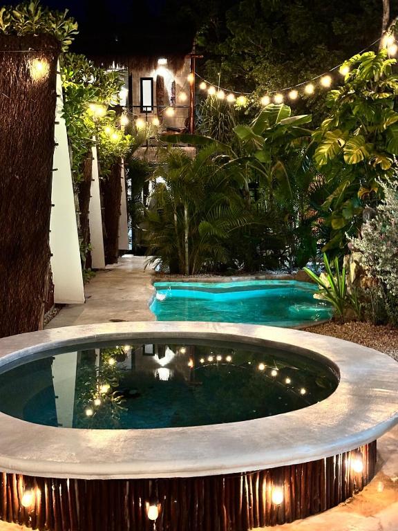 a swimming pool in a yard at night with lights at Aldea Pukna Tulum in Akumal