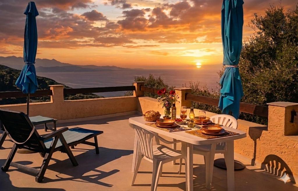 a table and chairs on a patio with the sunset at Location cap corse in Canari