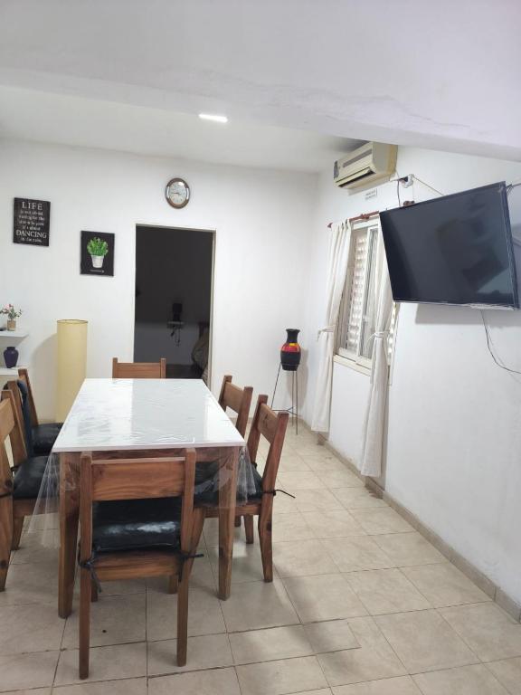 a dining room with a table and a flat screen tv at Departamento Don Nico in San José de la Dormida