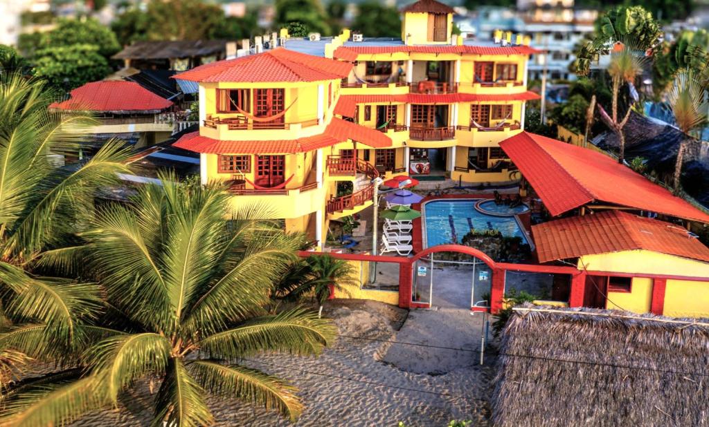 an aerial view of a large yellow building with red roofs at Hotel Cielo Azul in Atacames