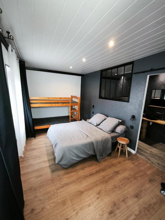 a bedroom with a bed and a wooden floor at Studio des 3 bassins in La Chapelle-Blanche