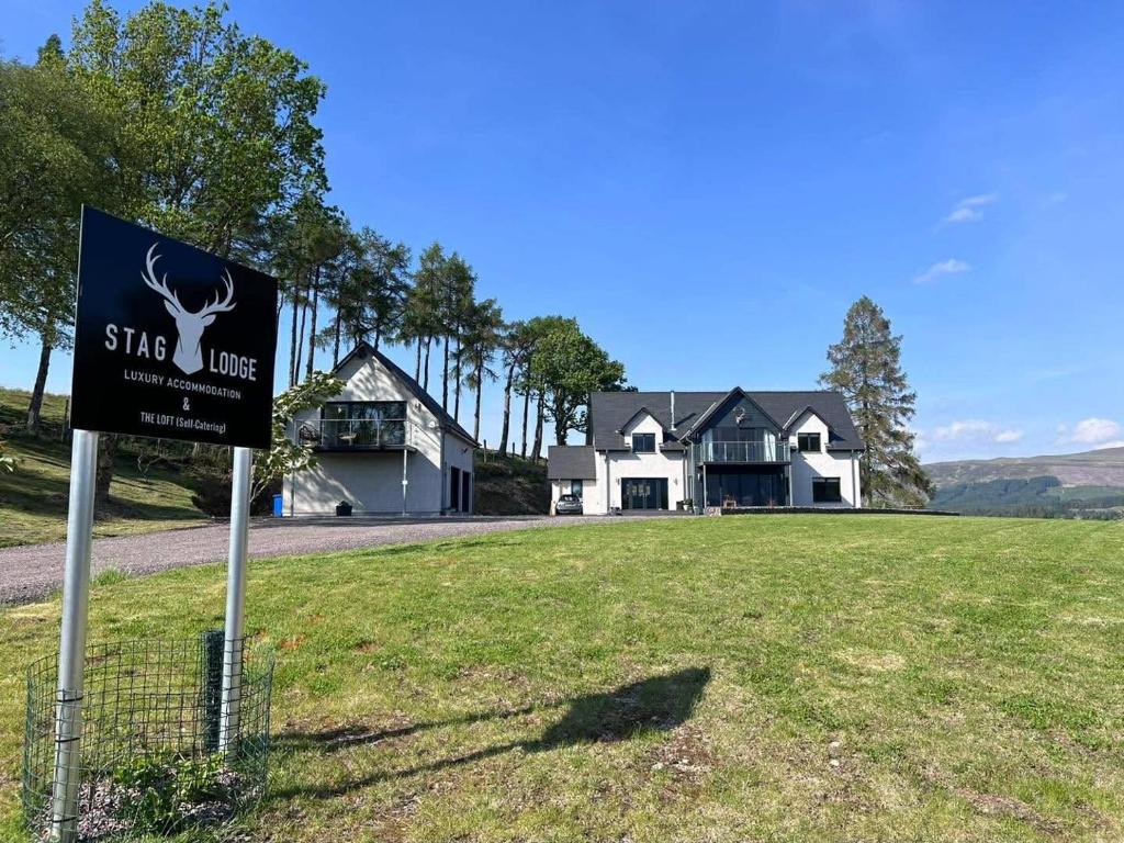 a sign in a field in front of a house at Stag Lodge in Spean Bridge
