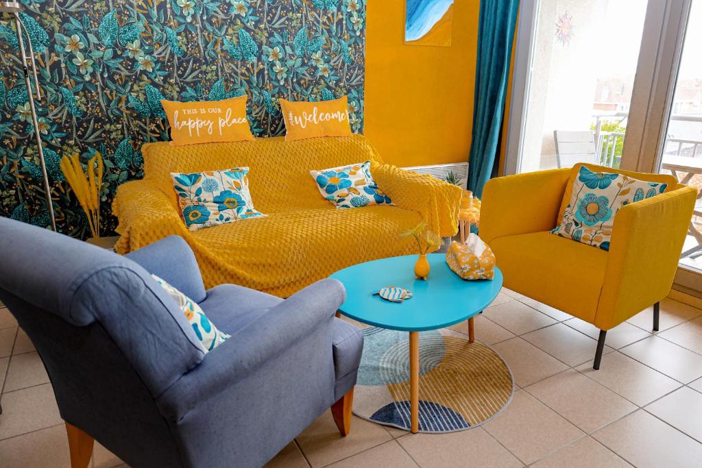 a living room with a couch and a table at La villa Margats - Charme & détente en bord de mer in Bray-Dunes