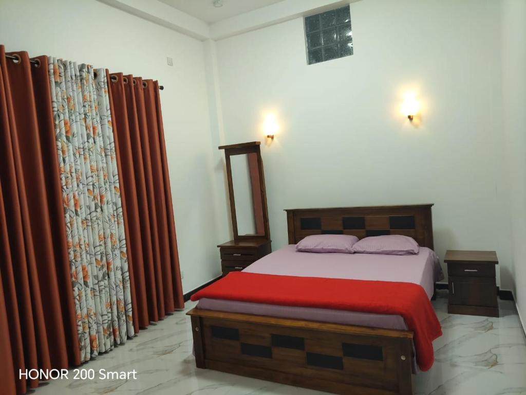 a bedroom with a bed with a red blanket at cassiopeia escape in Kottawa
