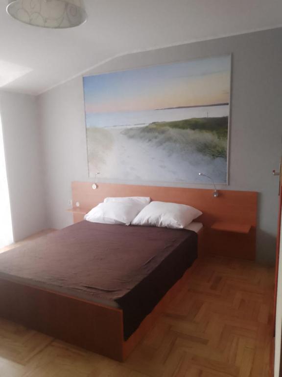 a bedroom with a bed with a painting on the wall at Pokoje u Jolanty in Władysławowo