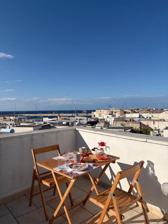 a table and chairs on a balcony with a view of the ocean at Sea Breeze Terrace in Monopoli