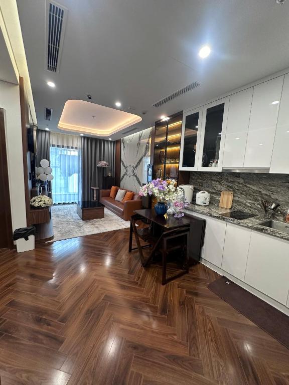 a kitchen and living room with wooden floors and white cabinets at 7Homestay in Hai Phong