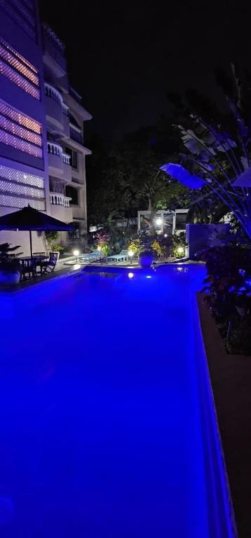 a large swimming pool at night with blue lights at EBENEZER Apartment in Diani Beach