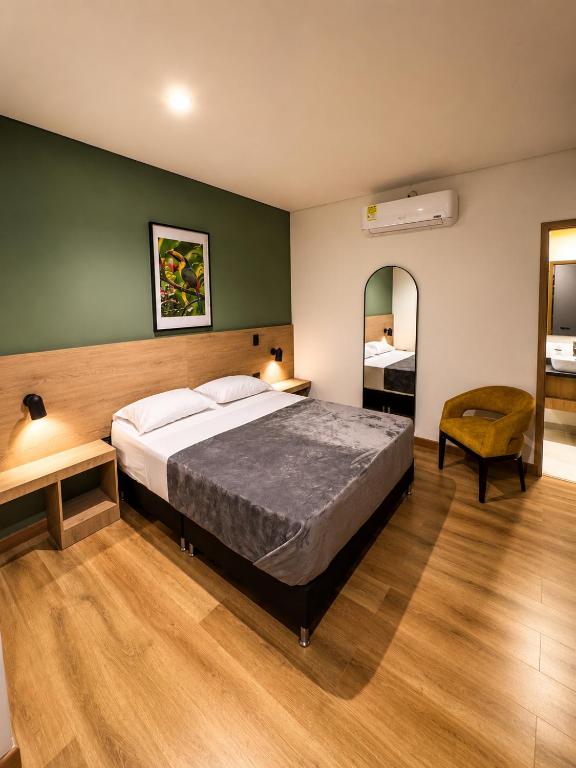 a bedroom with a large bed and a green wall at Habitat Ochentayuno in Medellín