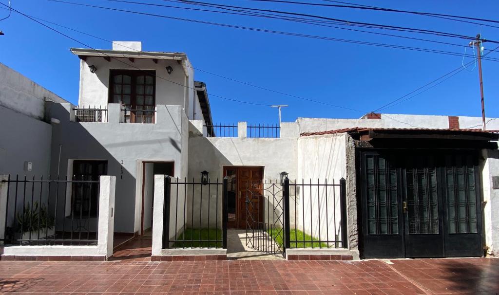 a white house with a gate in front of it at Casita de Norma, Mercedes Corrientes!!! in Mercedes