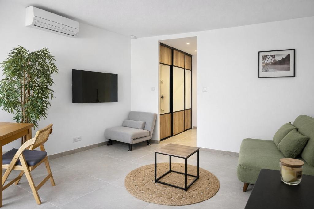 a living room with a couch and a table at Cosy Sunnyland, accès direct plage et parking privatif in La Grande Motte