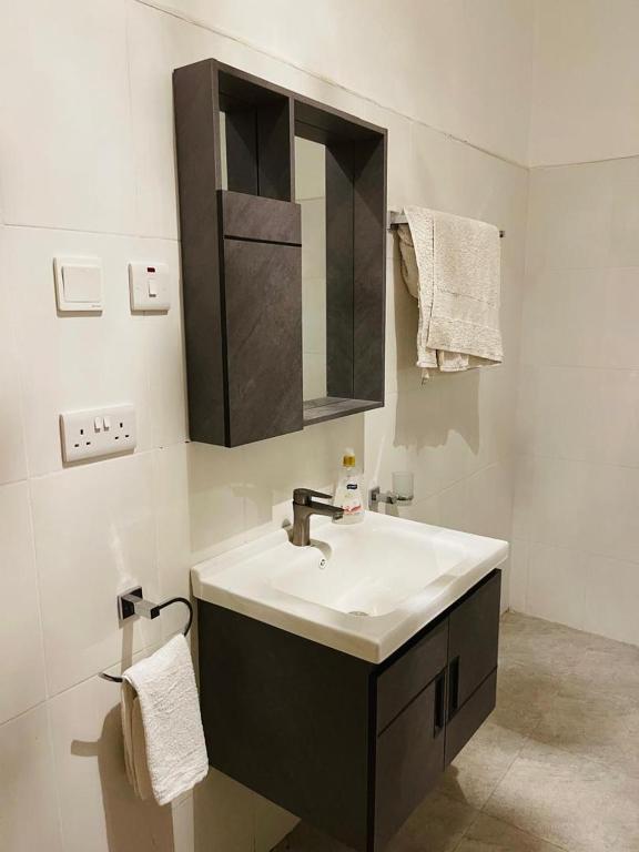 a bathroom with a sink and a mirror at Almasi lounge in Arusha