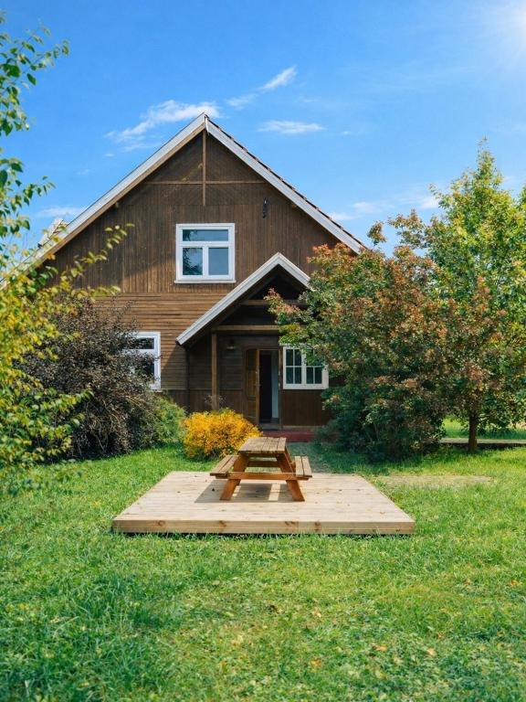 a wooden house with a picnic table in front of it at agroOBERIBA in Płatkownica