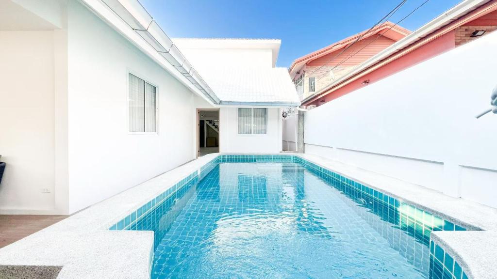a swimming pool in the backyard of a house at Pattaya Tropical Pool Villa in Pattaya