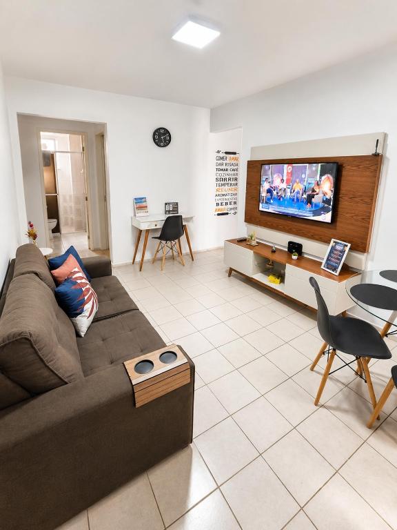 a living room with a couch and a flat screen tv at Apto Completo Ar e Wi-Fi Parque Itaimbe in Santa Maria