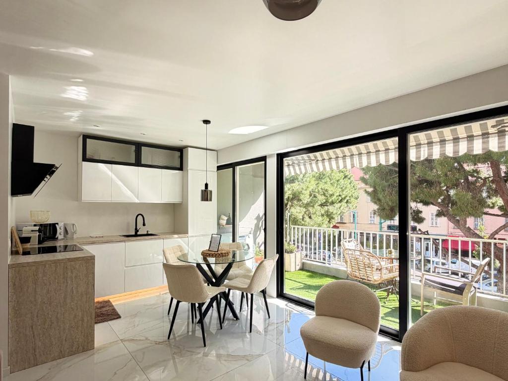 a kitchen and dining room with a table and chairs at Le Soleil Tropézien, Somptueux 2 pièces - Terrasse Vue Mer in Menton