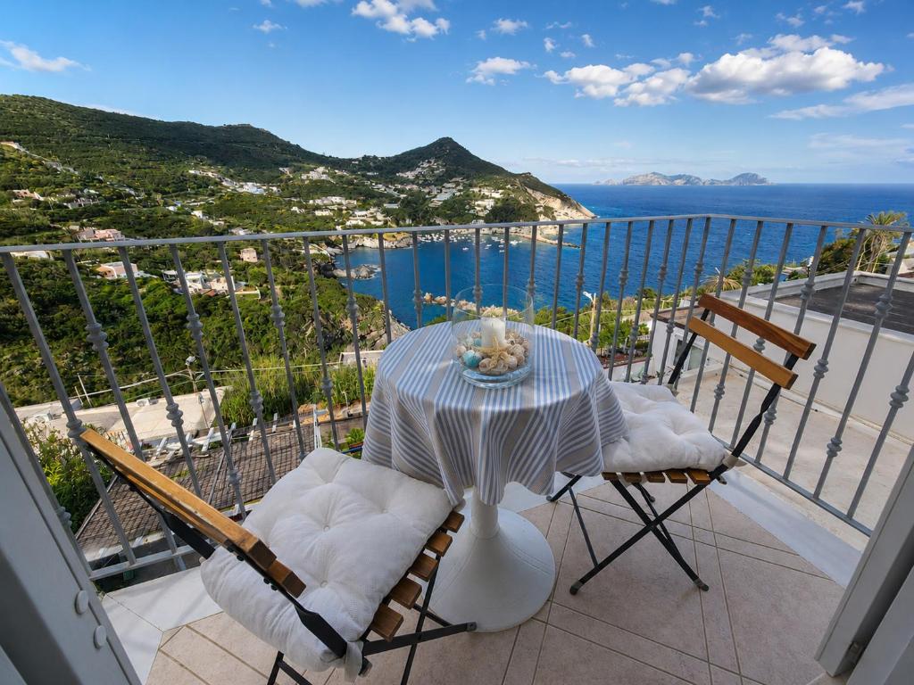 a table and chairs on a balcony with a view of the ocean at Maridea - Appartamento al Tramonto in Ponza