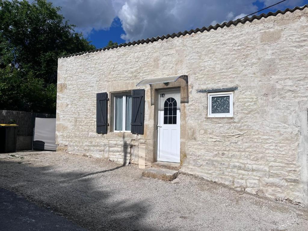 a stone building with a white door and a window at Studio in Nanteuil-en-Vallée