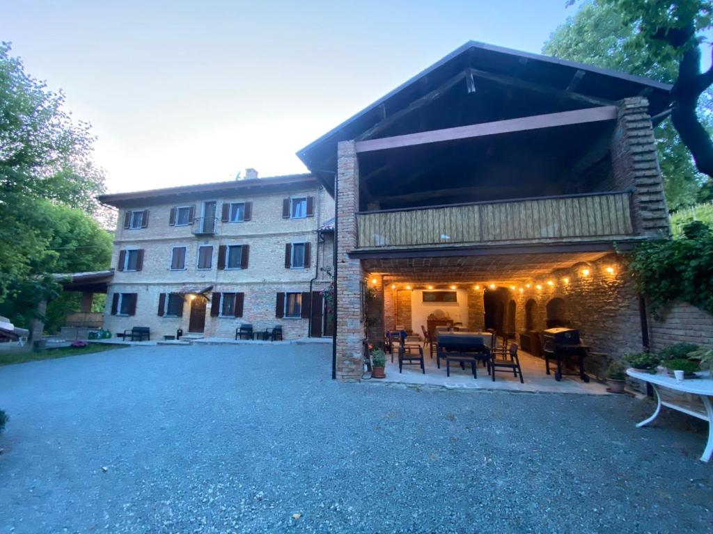 a building with a table and chairs in front of it at Agriturismo Cascina Frati in Canelli