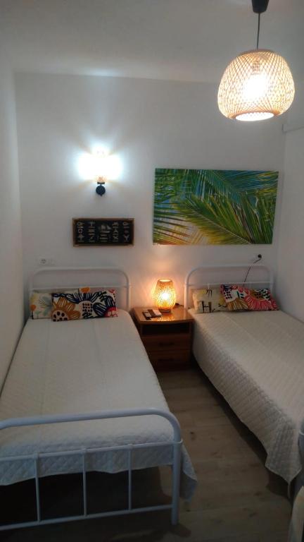 a bedroom with two beds and a table with a lamp at Studio apartman Marija 2 in Bol