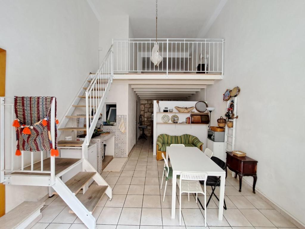 a room with a staircase and a table and chairs at Appartamento in Centro casa vacanza in Scicli