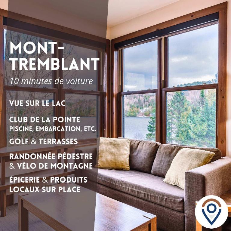 a living room with a couch and a large window at Waterfront Suite & Lake Resort in Lac-Superieur