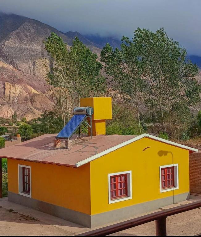 a small yellow house with a slide on the roof at La Posta de Gherard in Maimará