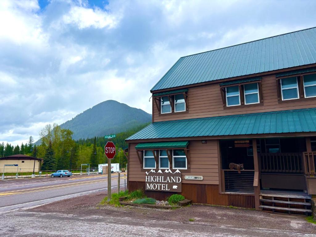 a building on the side of a road with a stop sign at Glacier Highland Motel in West Glacier