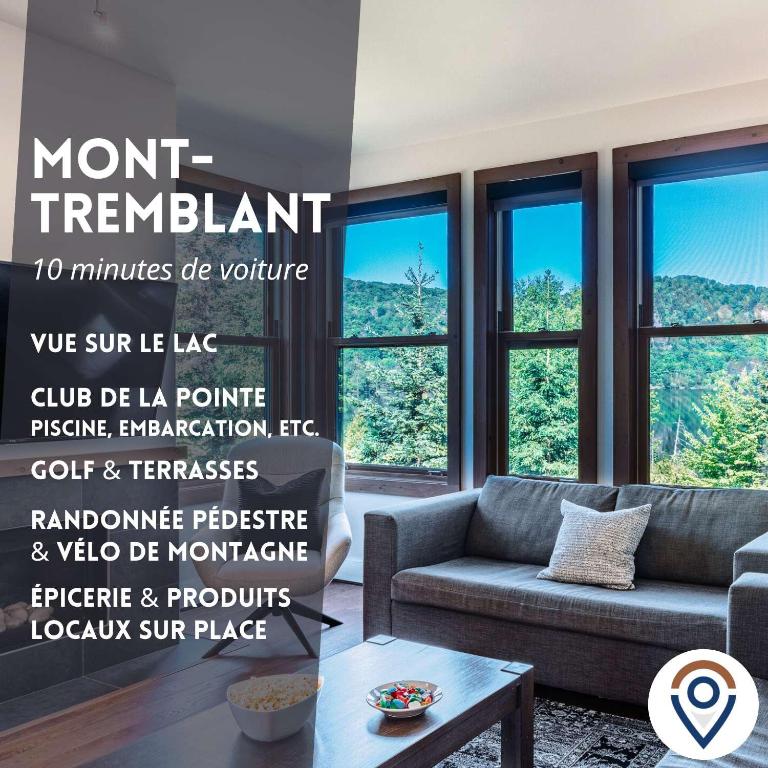 a living room with a couch and a wall of windows at Waterfront condo with magnificent view in Lac-Superieur