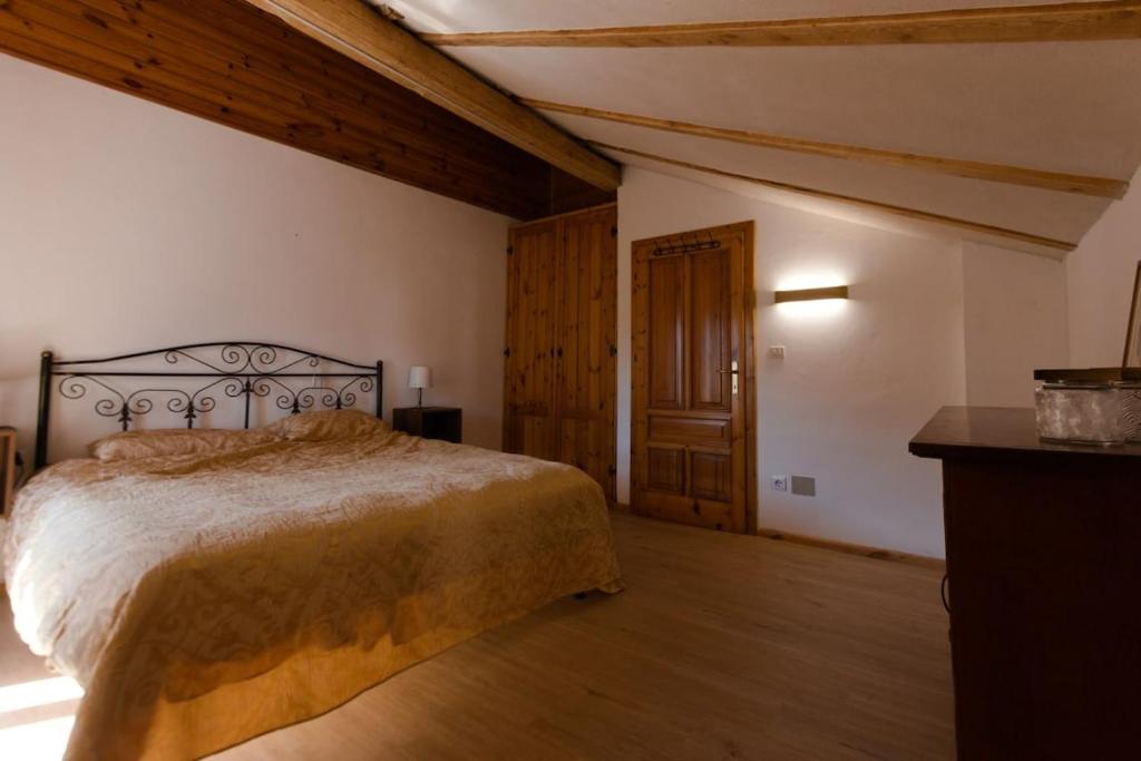 a bedroom with a bed and a wooden floor at Casa dello Scoiattolo in Bieno