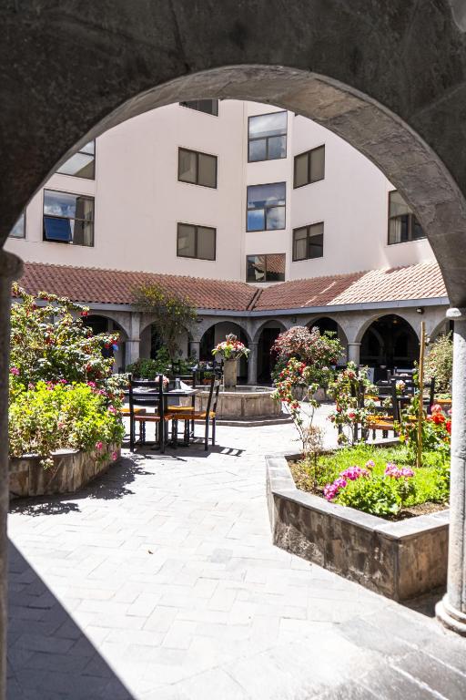 a courtyard with tables and chairs and a building at Hotel Jose Antonio Cusco in Cusco