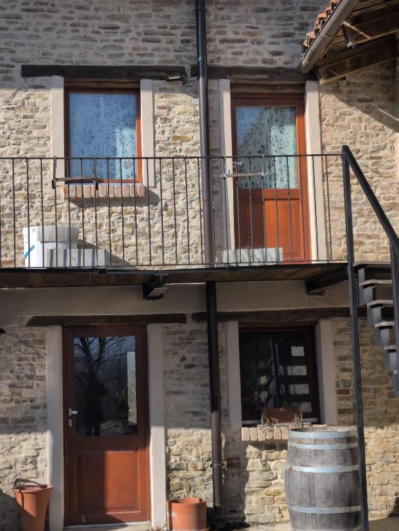 a brick building with a balcony and a door at Casa Vacanza in Serravalle delle Langhe
