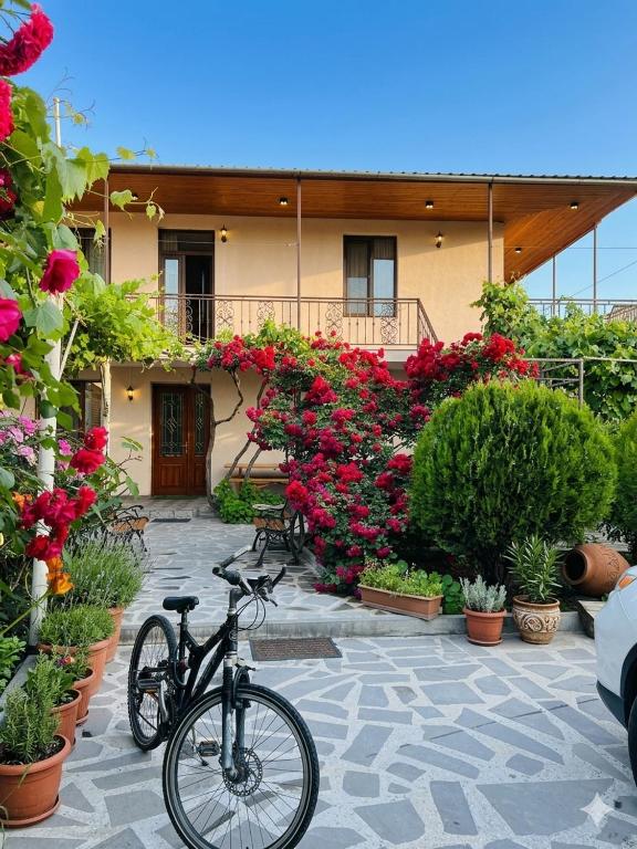 a bike parked in front of a building with flowers at vardzia Guesthouse Mtkvari in Nak'alak'evi