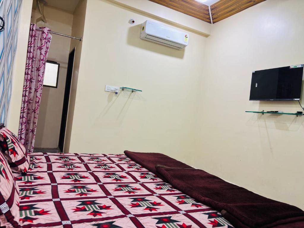 a room with a bed with a blanket on it at Sanatan lok in Ujjain
