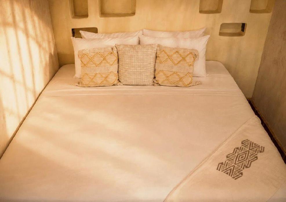 a large white bed in a small room with pillows at Casona Tunan in Santa María Mizata