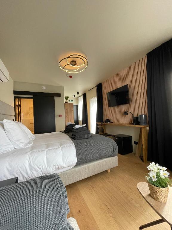 a hotel room with a large bed and a television at Hotel Mezza Notte in Ronse