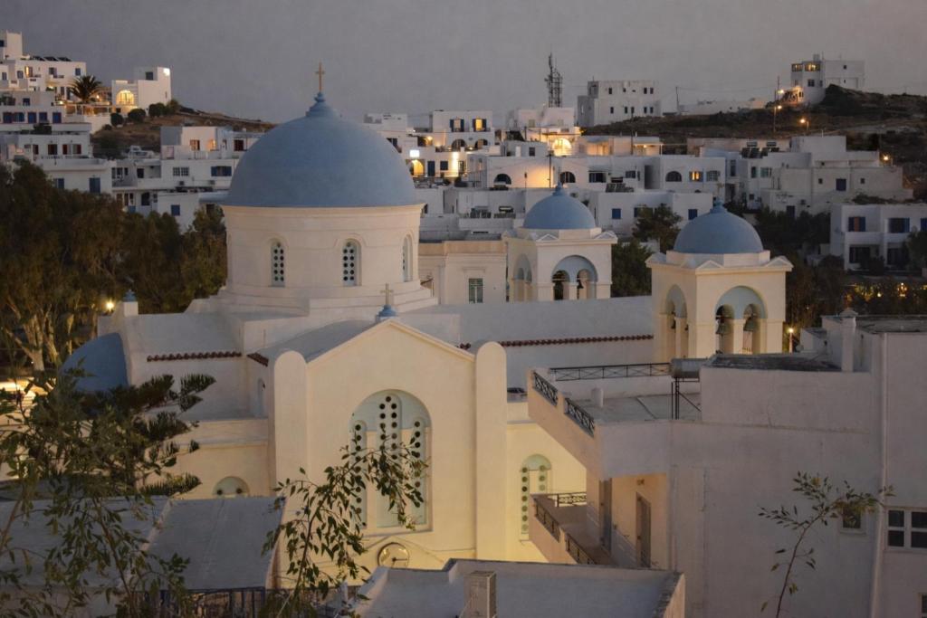 a white church with domes on top of a city at Aurelia Rooms in Ios Chora