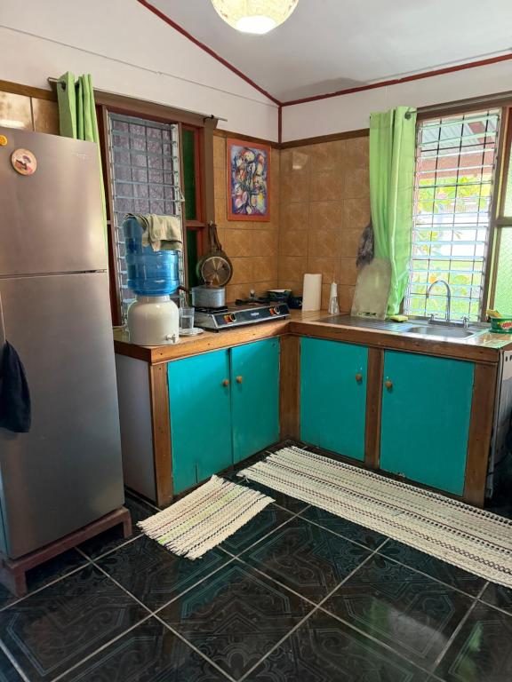 a kitchen with blue cabinets and a stainless steel refrigerator at My Caribe Casa in Puerto Viejo