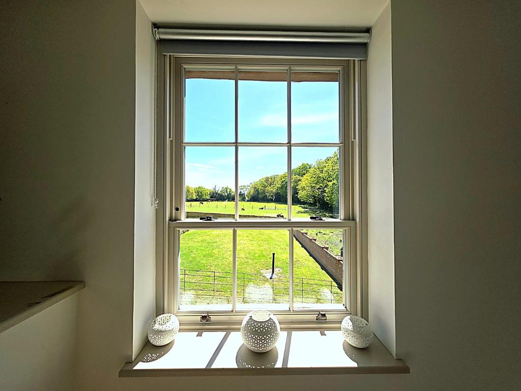 a window with three vases sitting on a window sill at The Hayloft in Ringwood